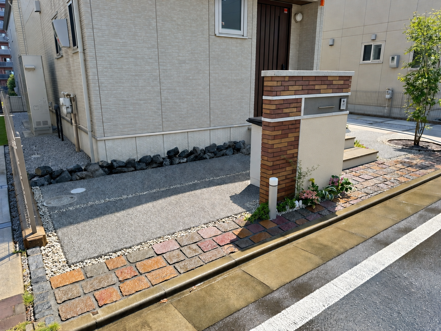 レンガタイルと塗り壁を組み合わせた造作門柱のある新築外構